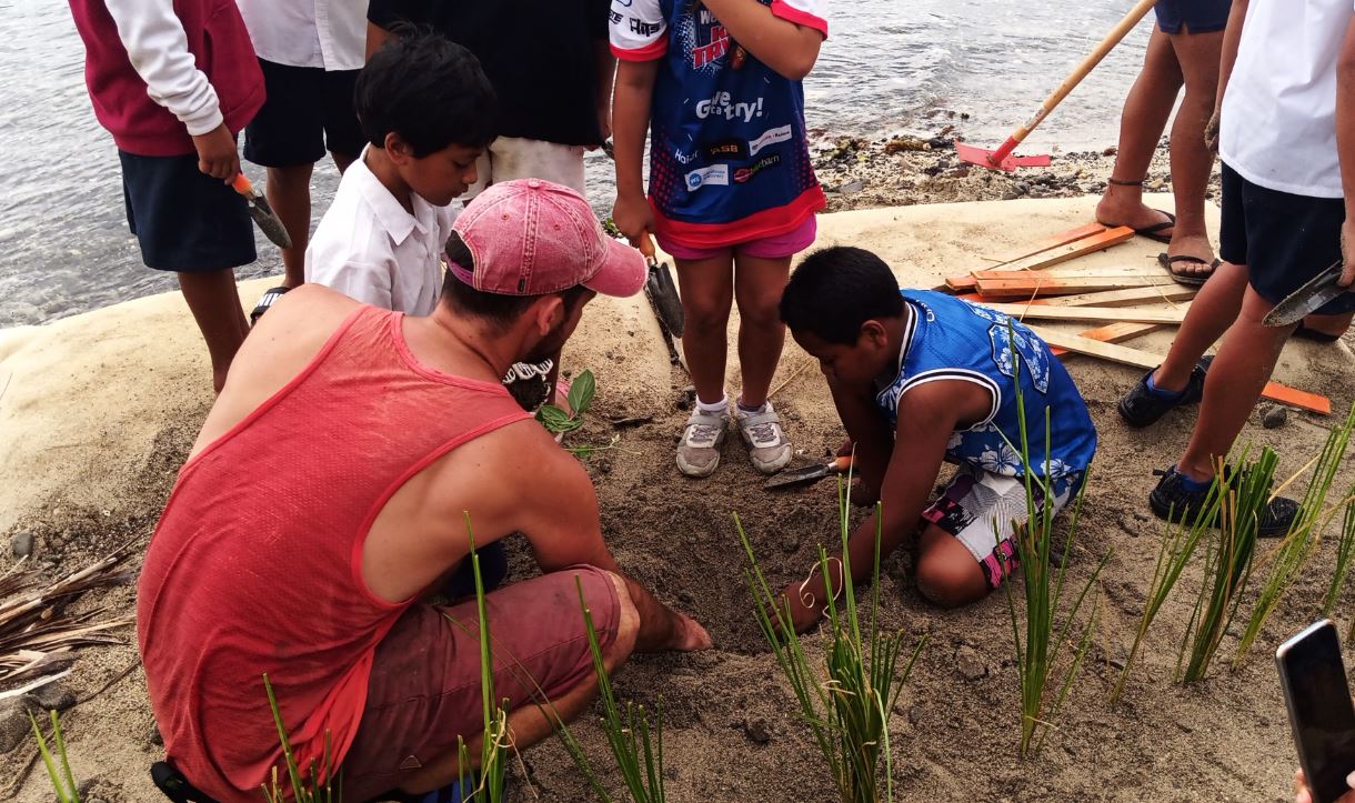 Students from Apii Takitumu and Apii Te Uki Ou planting erosion control vegetation at the Avana geobag revetment